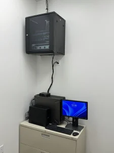 Tech365 mounted a Server rack mounted on wall with server computer workstation below it.