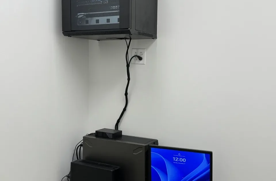 Tech365 mounted a Server rack mounted on wall with server computer workstation below it.